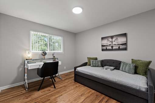 A bedroom with a bed, desk, and chair.
