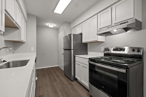 A modern kitchen with stainless steel appliances and white cabinetry.