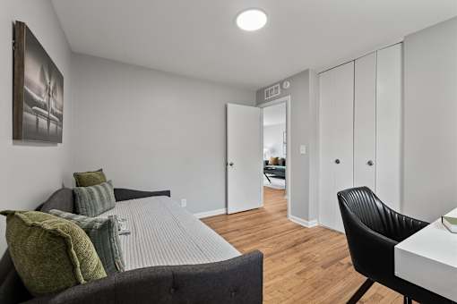 A bedroom with a bed, chair, and wardrobe.