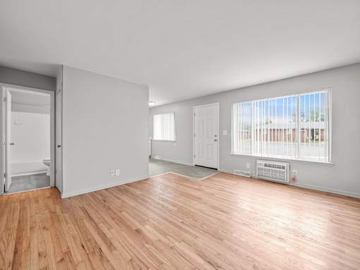 a bedroom with hardwood floors and grey walls