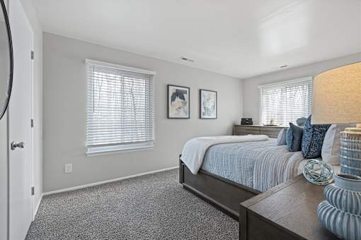 A bedroom with a bed, nightstand, and two framed pictures on the wall.
