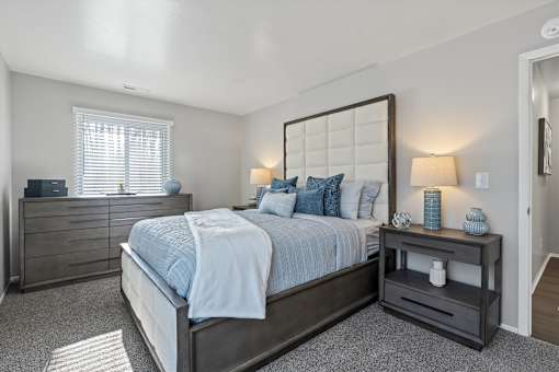 A bedroom with a bed, nightstand, and lamp.