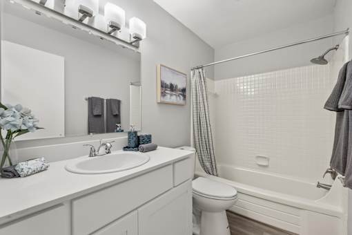 A white bathroom with a toilet, sink, and bathtub.