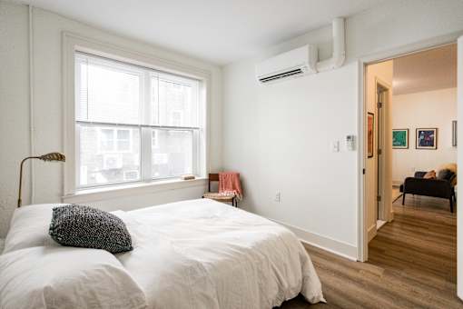 A bedroom with a large bed and a window.