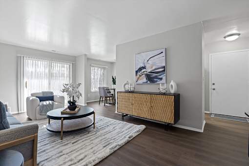 A modern living room with a coffee table, sofa, and a painting on the wall.