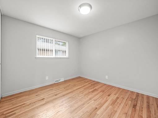 a bedroom with grey walls and a wooden floor