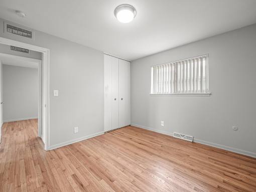 a bedroom with hardwood floors and grey walls