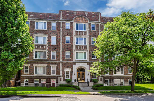 A large brick building with a green lawn in front.