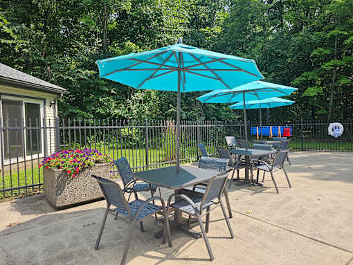 A table and chairs set up under a blue umbrella.