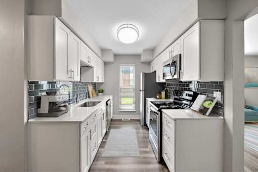 A modern kitchen with white cabinets and appliances.