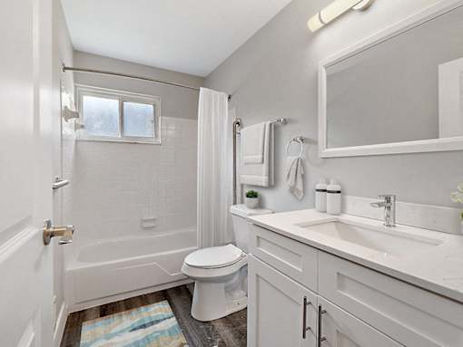 A white bathroom with a toilet, sink, and shower.