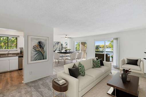A living room with a white couch and a painting on the wall.