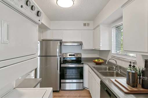 A modern kitchen with stainless steel appliances and white cabinets.