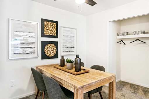 A dining room with a wooden table and chairs.