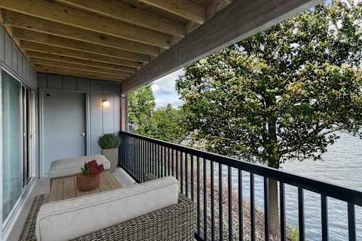 A balcony with a couch and a view of the water.