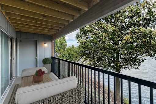 A balcony with a couch and a view of the water.