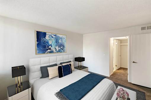 A bedroom with a large bed and a painting on the wall.