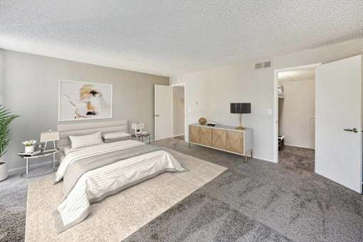 A bedroom with a large bed and a bench.