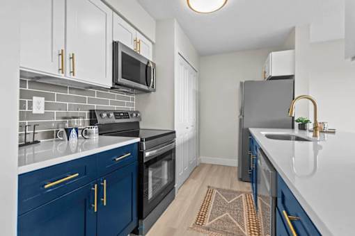 A kitchen with blue cabinets and a black oven.