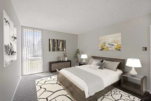A bedroom with a large bed and a painting on the wall.