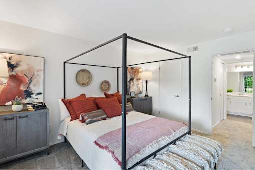 A bedroom with a four poster bed and a grey cabinet.