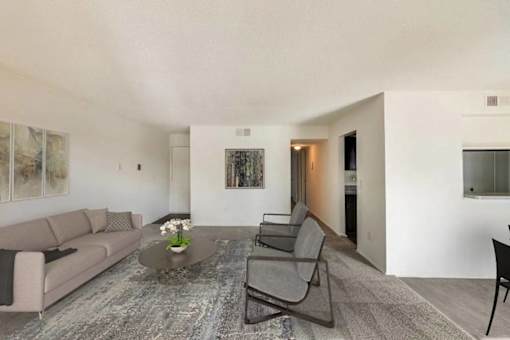 A living room with a grey sofa, a coffee table, and a grey chair.
