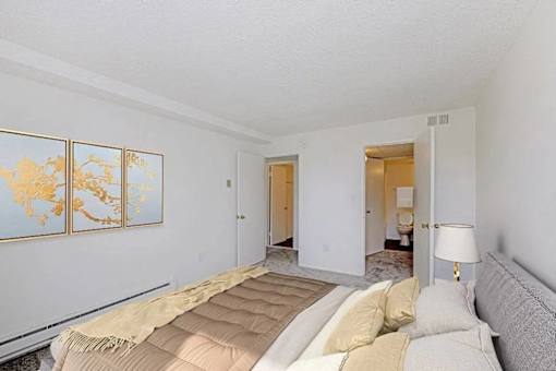 A bedroom with a bed, a lamp, and a map on the wall.