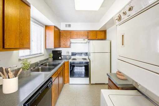 A kitchen with a white oven and black countertops.