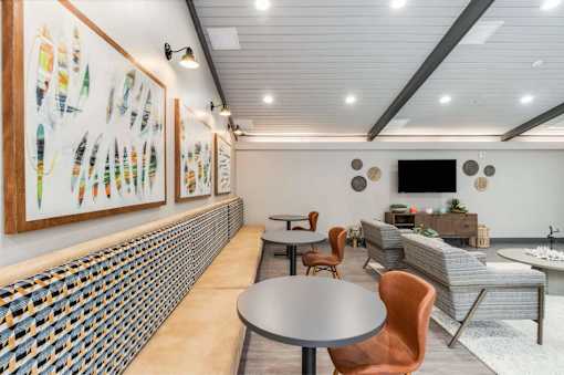 A room with a table, chairs and pictures on the wall.