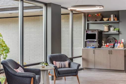 A modern living room with grey chairs and a grey sofa.