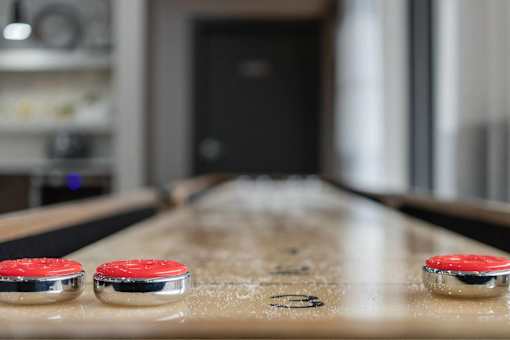 A table with two red buttons on it and a blurry background.