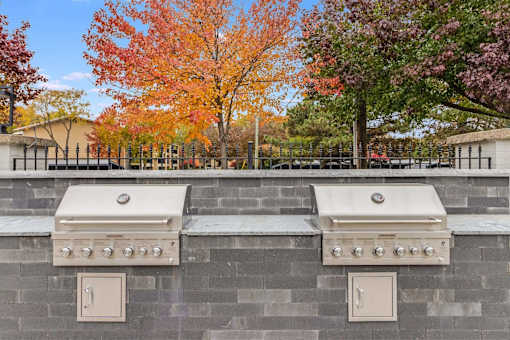 Two built-in BBQs on a stone wall.