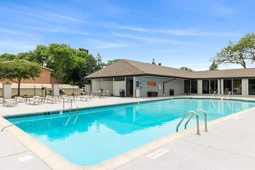 A large swimming pool with a building in the background.