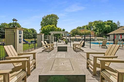 A sunny day at the park with wooden benches and a fence.