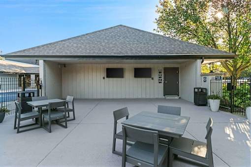 A patio with a table and chairs is set up outside a house.