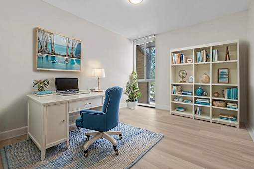 A room with a desk, chair, and bookshelf.