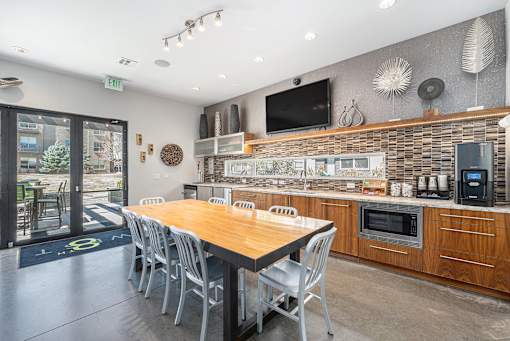 A modern kitchen with a wooden table and chairs.