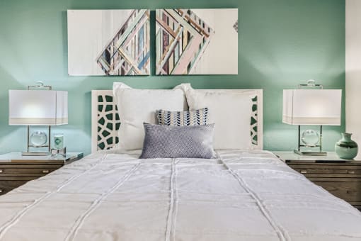 a bedroom with green walls and a white bed with a white comforter