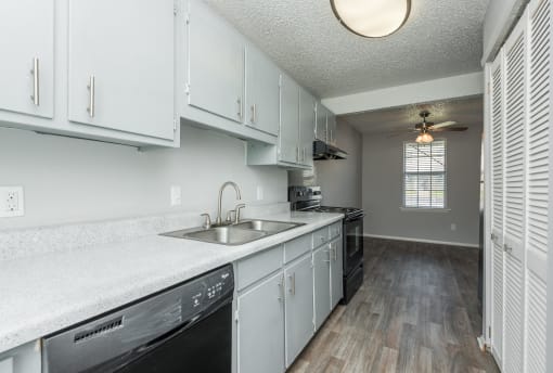 an empty kitchen with white cabinets and a sink