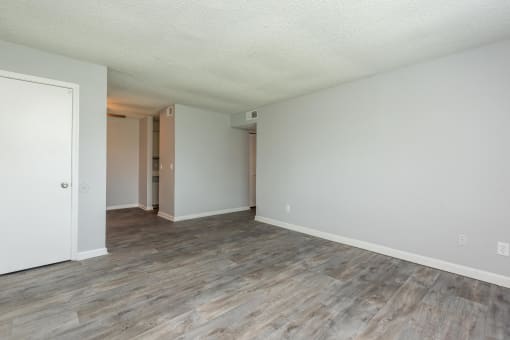 an empty living room with white walls and wood flooring