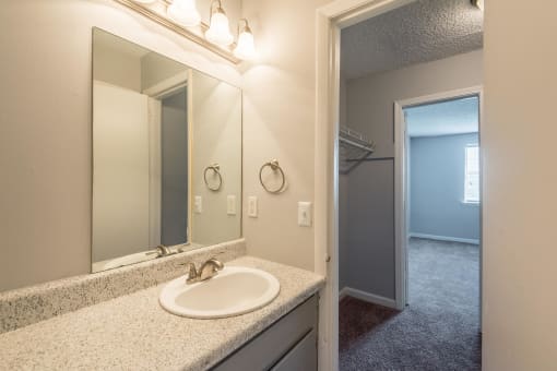 a bathroom with a sink and a mirror and a closet
