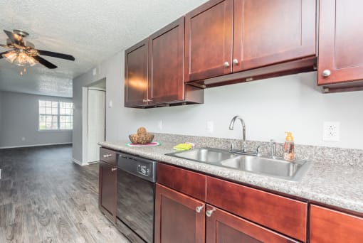 a kitchen with wooden cabinets and a stainless steel sink