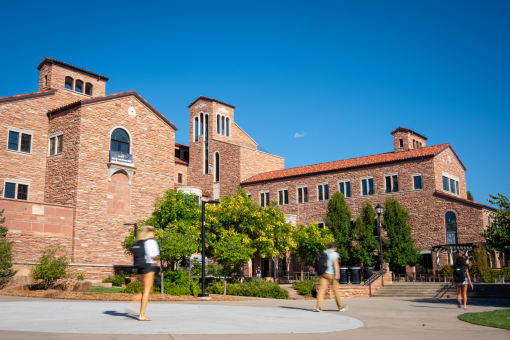 people walking in front of a brick building on the campus