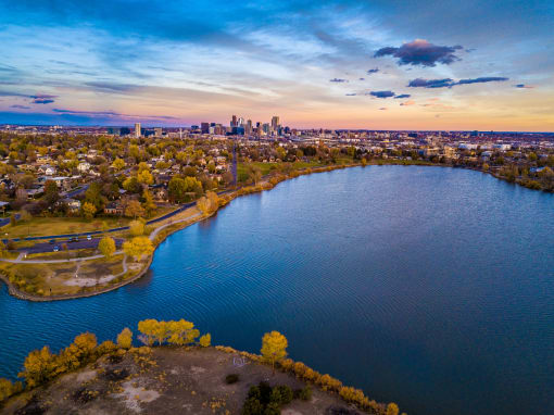 an aerial view of a lake with a city skyline in the background
