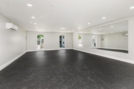 an empty room with a black floor and white walls