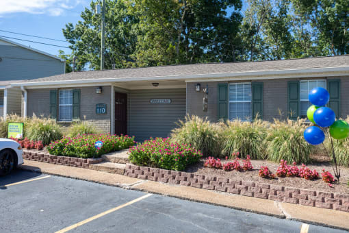 a home with a lawn and flowers in front of it