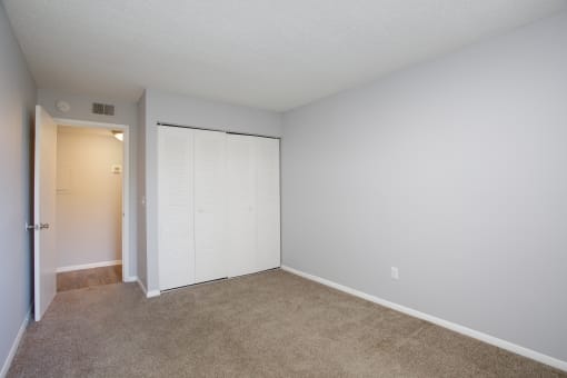 a bedroom with a closet and a door to the bathroom