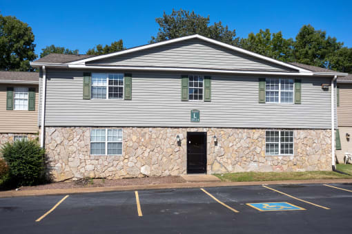 a white house with a blue roof and a parking lot