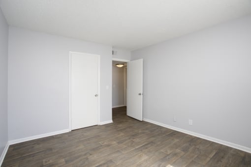 an empty living room with white walls and wood flooring