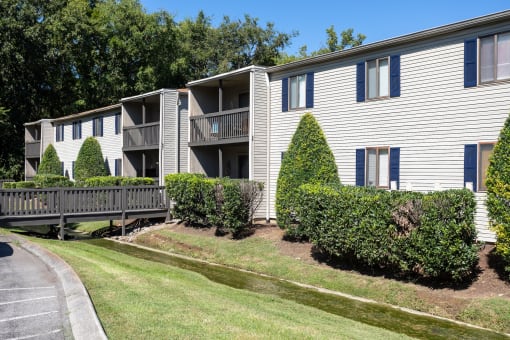 an exterior view of an apartment building with a wooden deck and bushes